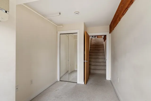 a view of a hallway with wooden floor and closet