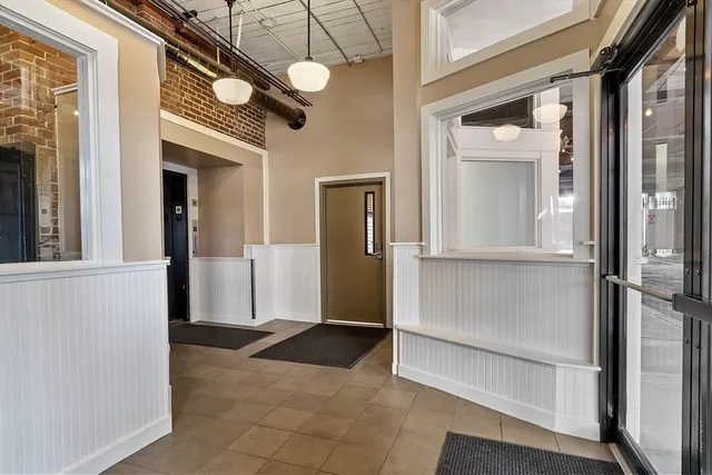 a view of a hallway with a glass door and a window