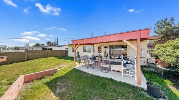 a view of a patio with table and chairs potted plants with wooden floor and fence