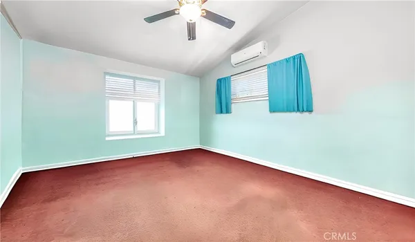 an empty room with a window and a ceiling fan