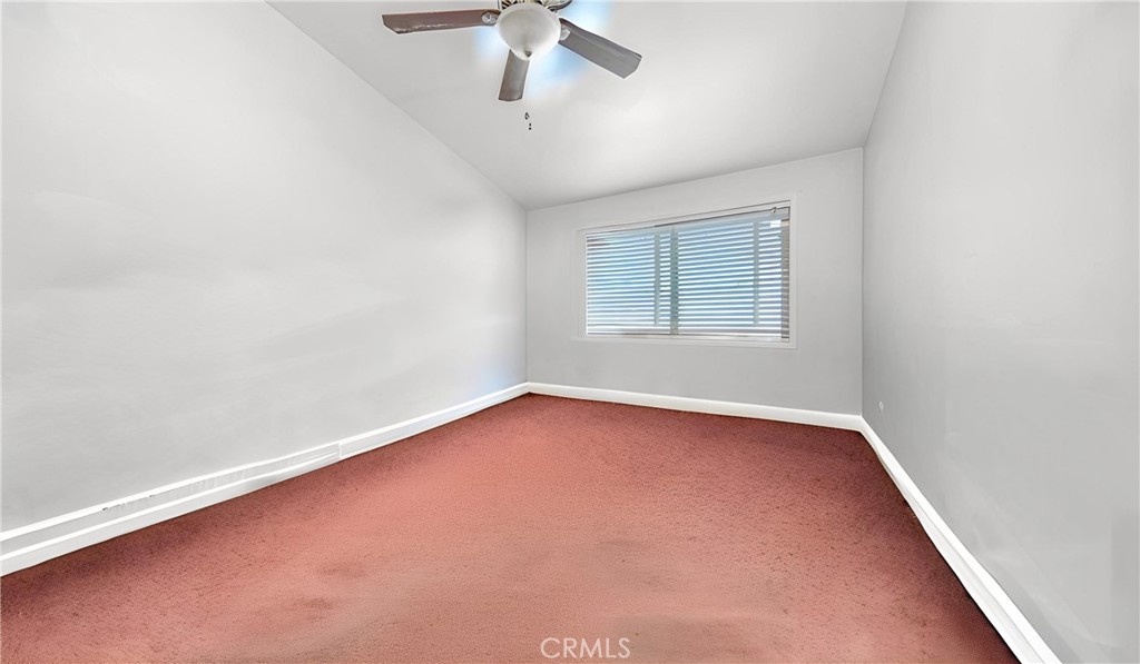 1549 Elizabeth Lake Road Palmdale, CA 93551 - Photo 26 of 27 an empty room with a chandelier fan and windows