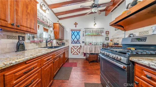 a large kitchen with stainless steel appliances granite countertop a stove and a sink
