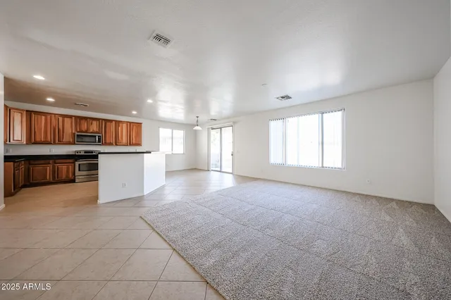 a view of a kitchen with kitchen island wooden floor and stainless steel appliances