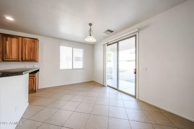 a view of an empty room with window and chandelier