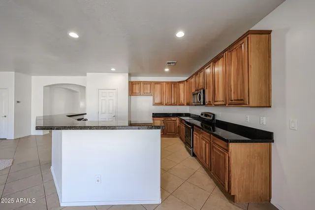 a kitchen with stainless steel appliances granite countertop a sink stove and cabinets