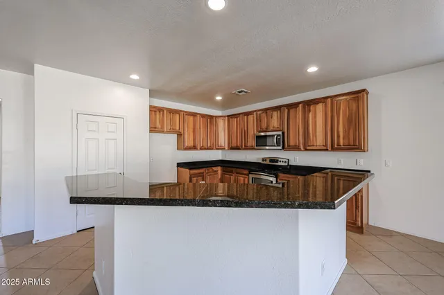 a kitchen with kitchen island granite countertop a sink and a granite counter tops