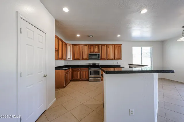 a kitchen with stainless steel appliances granite countertop a stove a sink and a refrigerator