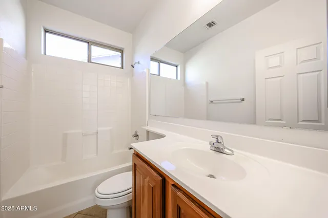 a bathroom with a sink toilet vanity and shower