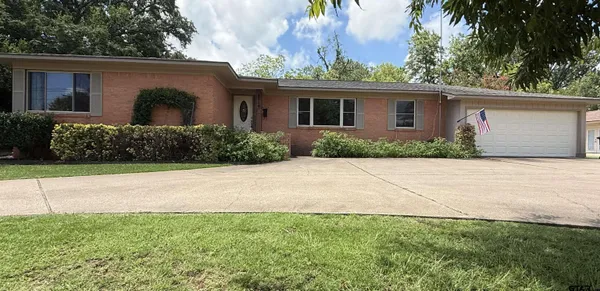a front view of house with yard and trees around