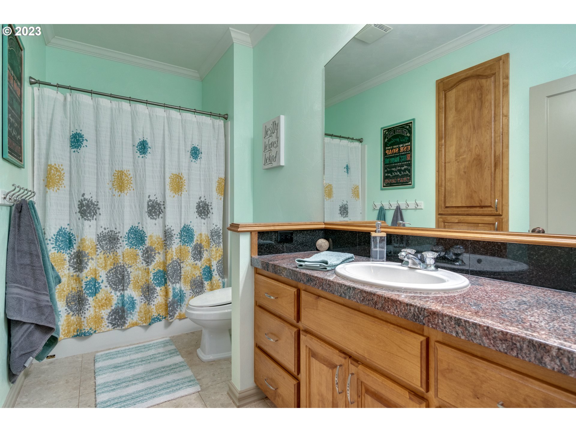 1675 South Boones Ferry Road Woodburn, OR 97071 - Photo 23 of 45 a bathroom with a granite countertop sink a toilet a mirror and shower curtain