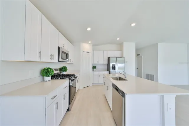 a kitchen with white cabinets sink and white appliances