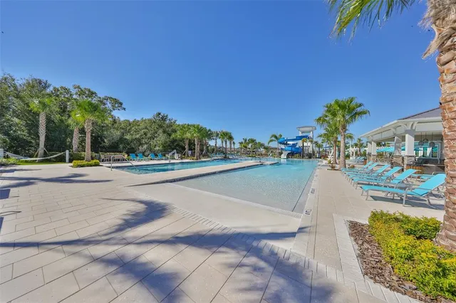 a view of a patio with table and chairs potted plants and large windows