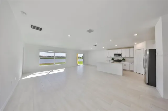 a view of kitchen with refrigerator stove and white cabinets