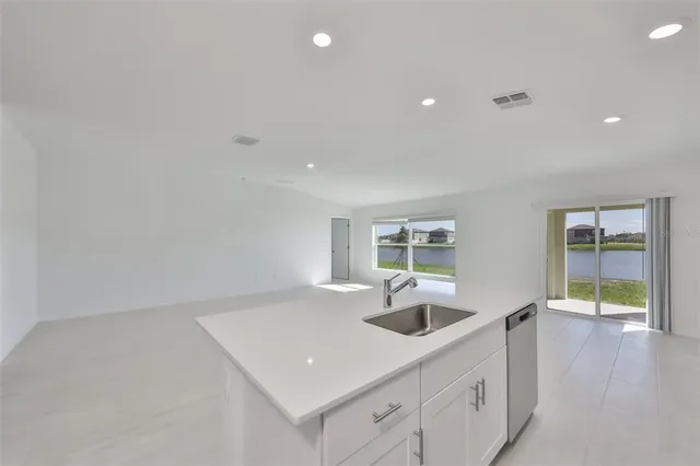 a view of kitchen with refrigerator sink and cabinets