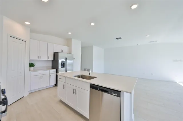 a kitchen with stainless steel appliances a refrigerator sink stove microwave and cabinets