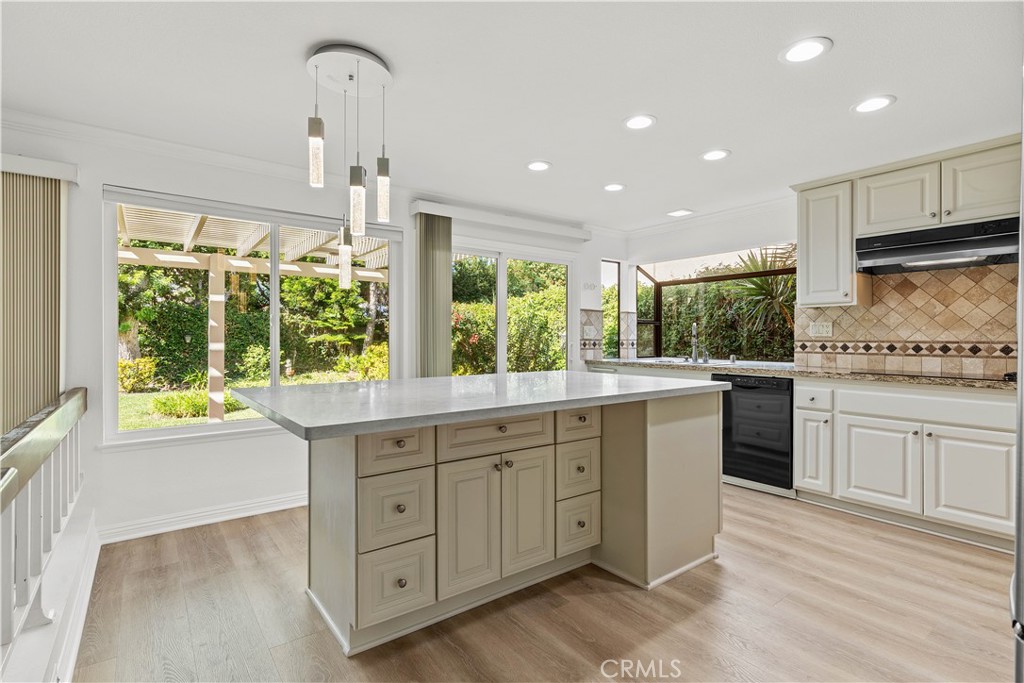 19 Alameda Irvine, CA 92620 - Photo 21 of 55 a kitchen with kitchen island granite countertop a stove and a sink