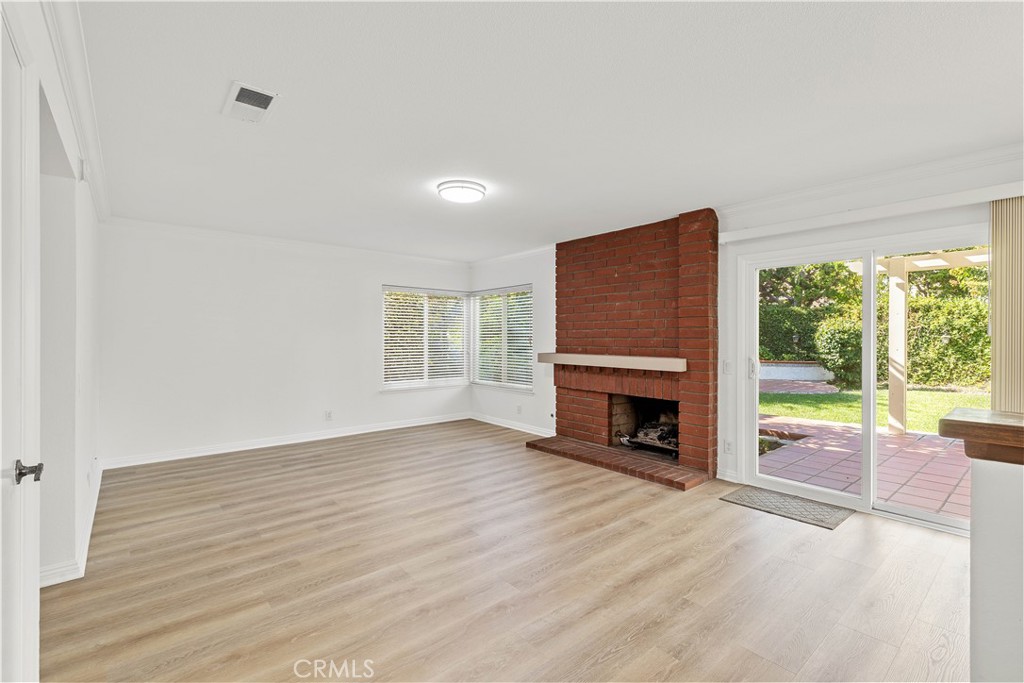 19 Alameda Irvine, CA 92620 - Photo 27 of 55 a view of a livingroom with a fireplace a ceiling fan and wooden floor