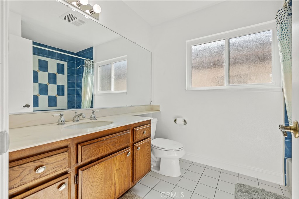 19 Alameda Irvine, CA 92620 - Photo 44 of 55 a bathroom with a granite countertop sink mirror vanity and toilet