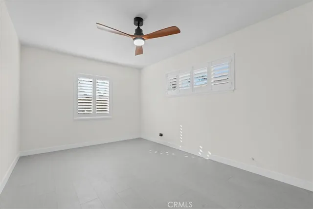 an empty room with a window and a fan