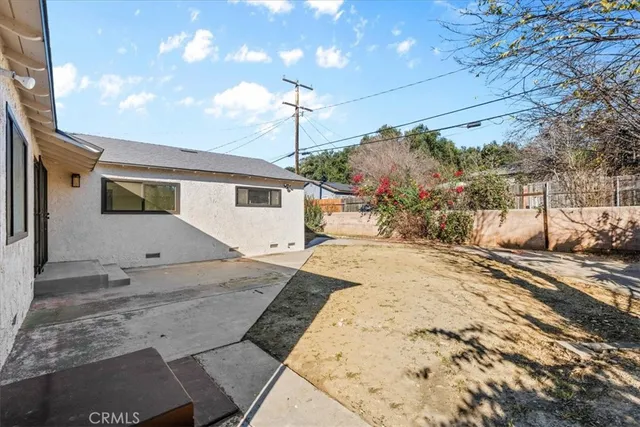 a front view of house with yard and trees around