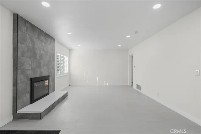 an empty room with windows and fireplace