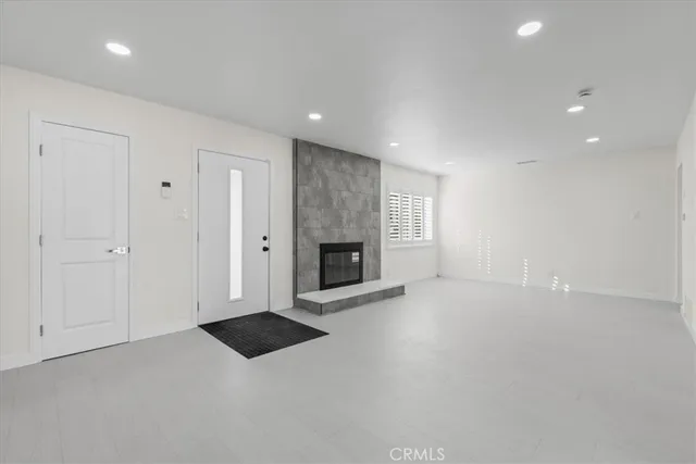 an empty room with windows and fireplace