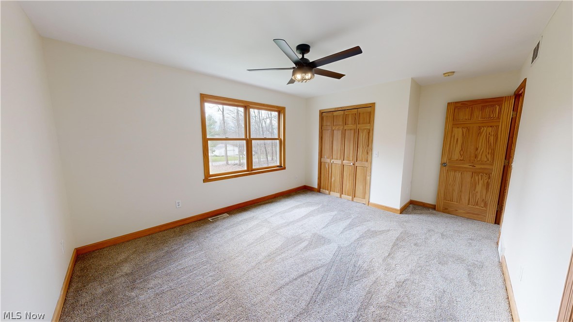 15548 Trask Road Thompson, OH 44086 - Photo 25 of 31 Third bedroom with light carpet, a closet, and ceiling fan