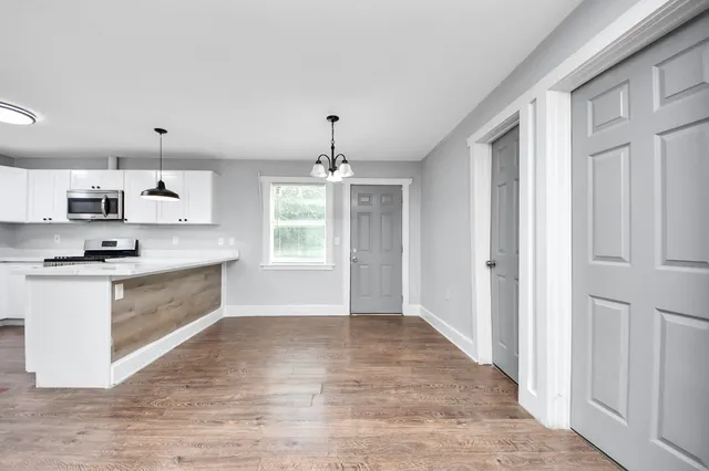 a large kitchen with kitchen island white cabinets and stainless steel appliances