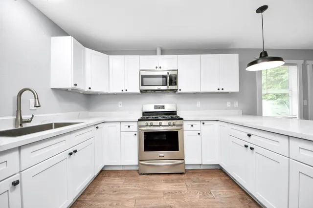 a kitchen with cabinets appliances and a sink