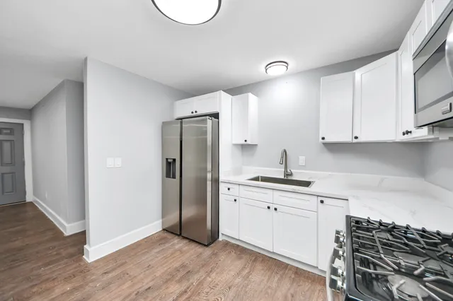 a kitchen with stainless steel appliances a stove a refrigerator and cabinets