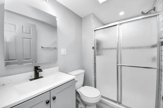 a bathroom with a sink a toilet and shower