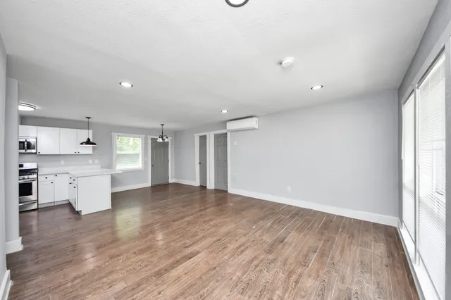 a view of a kitchen with wooden floor and a window