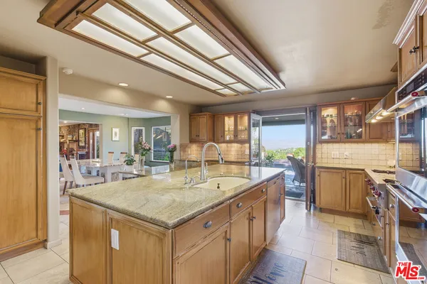 a large kitchen with kitchen island a stove a sink dishwasher and cabinets with wooden floor