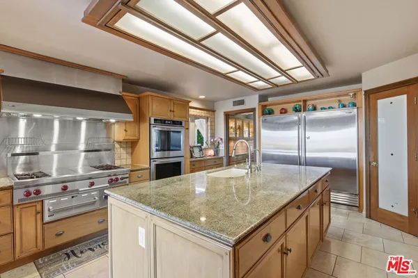 a kitchen with stainless steel appliances granite countertop a sink window and refrigerator