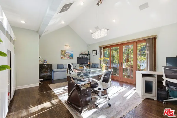 a living room with furniture a large window and wooden floor