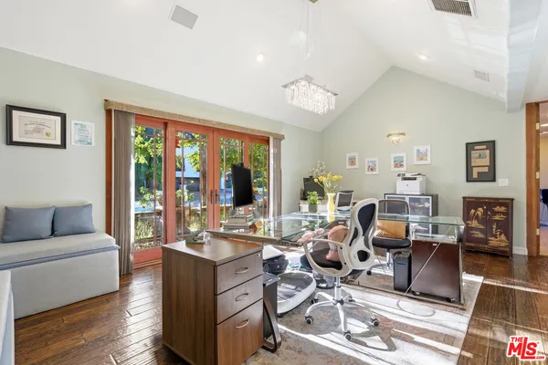 a living room with furniture large window and wooden floor