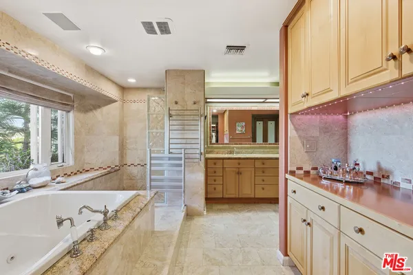 a spacious bathroom with a granite countertop tub sink and mirror