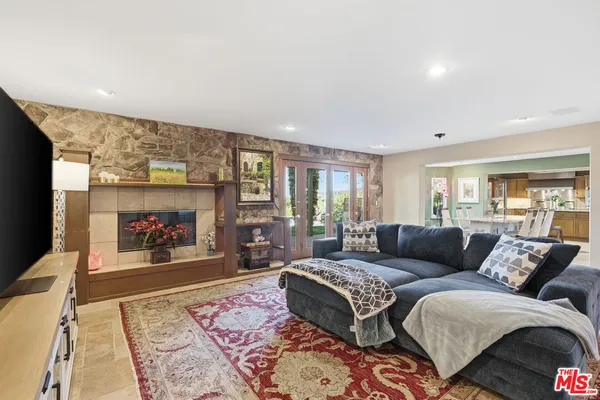 a living room with furniture two window and a fireplace