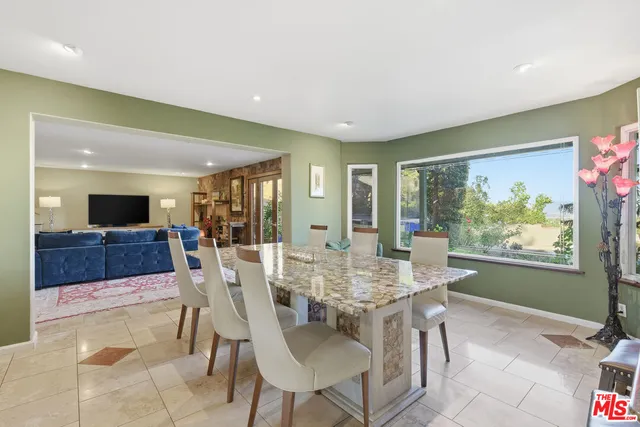 a dining room with furniture a window and a kitchen
