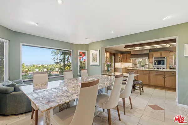 a dining room with furniture and a large window