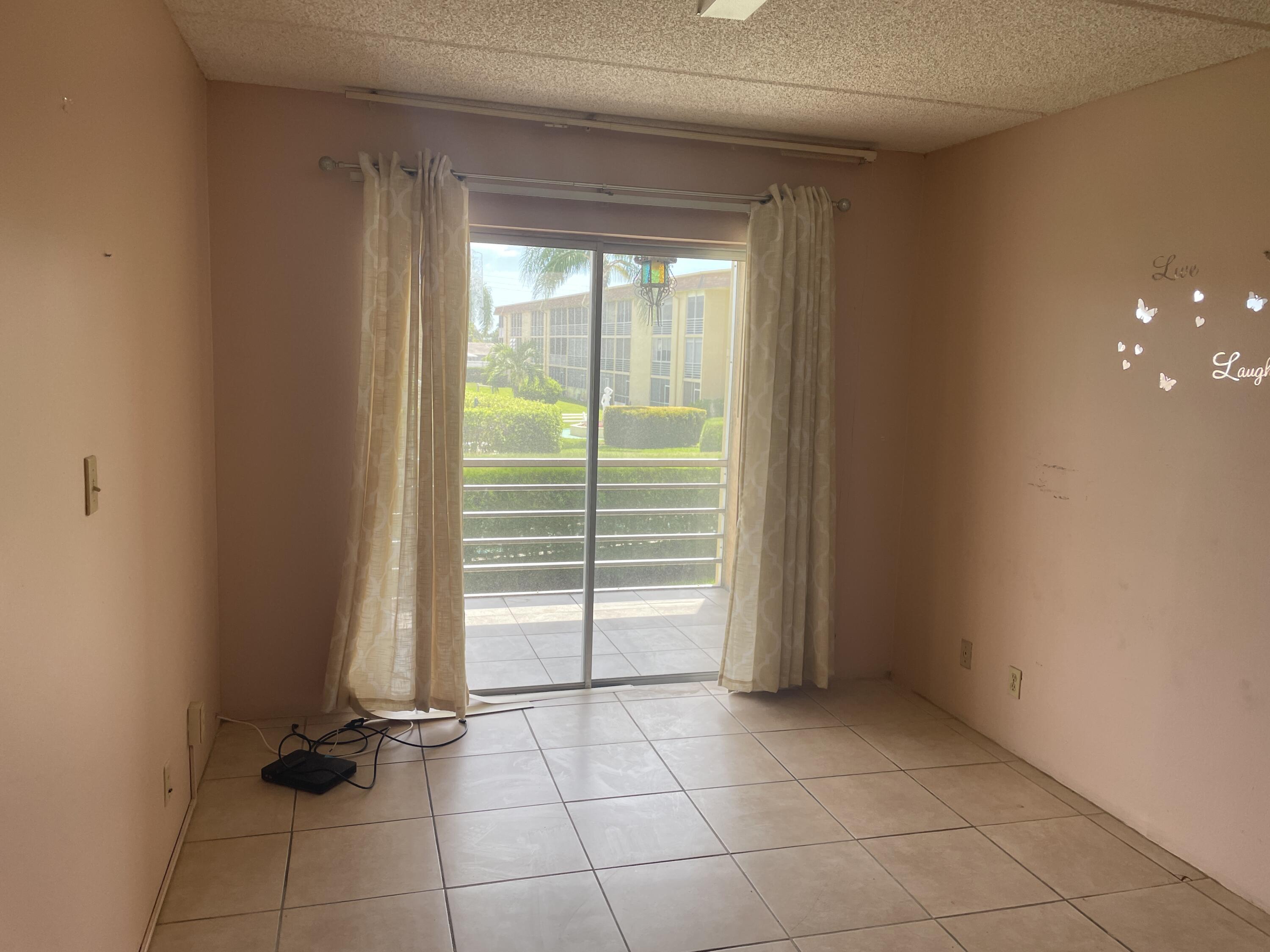 500 Village Green Circle West, Unit 212 Palm Springs, FL 33461 - Photo 12 of 23 a view of an empty room with a window