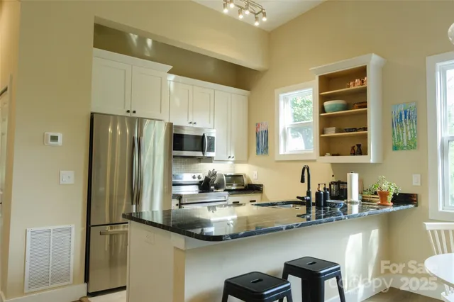 a kitchen with kitchen island a sink appliances and cabinets