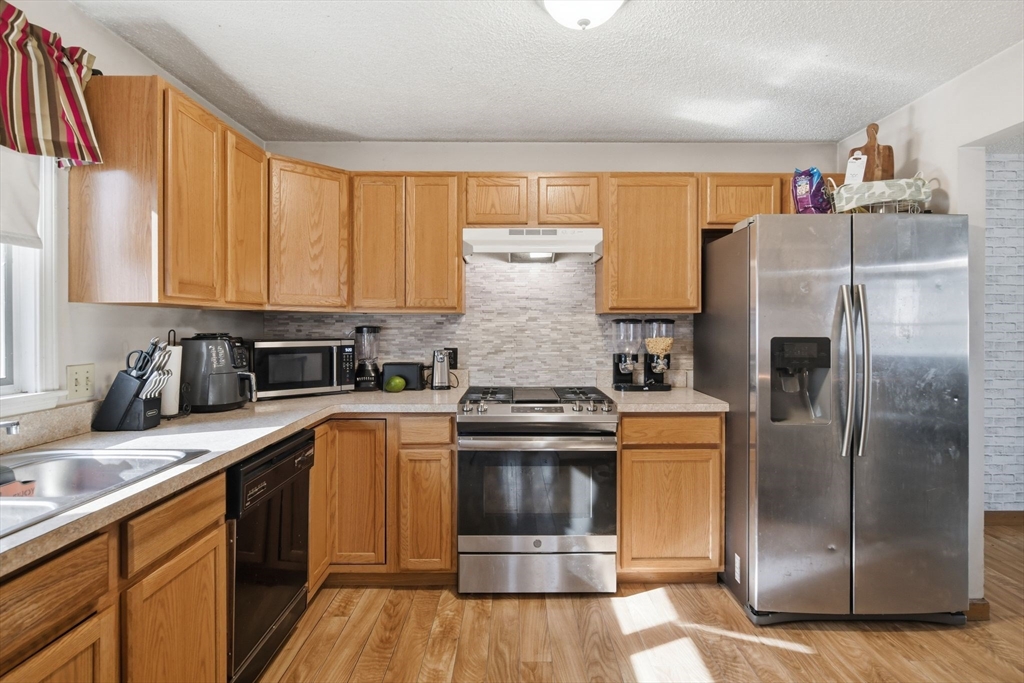222 Edendale Street Springfield, MA 01104 - Photo 13 of 36 a kitchen with stainless steel appliances granite countertop a refrigerator a sink and white cabinets