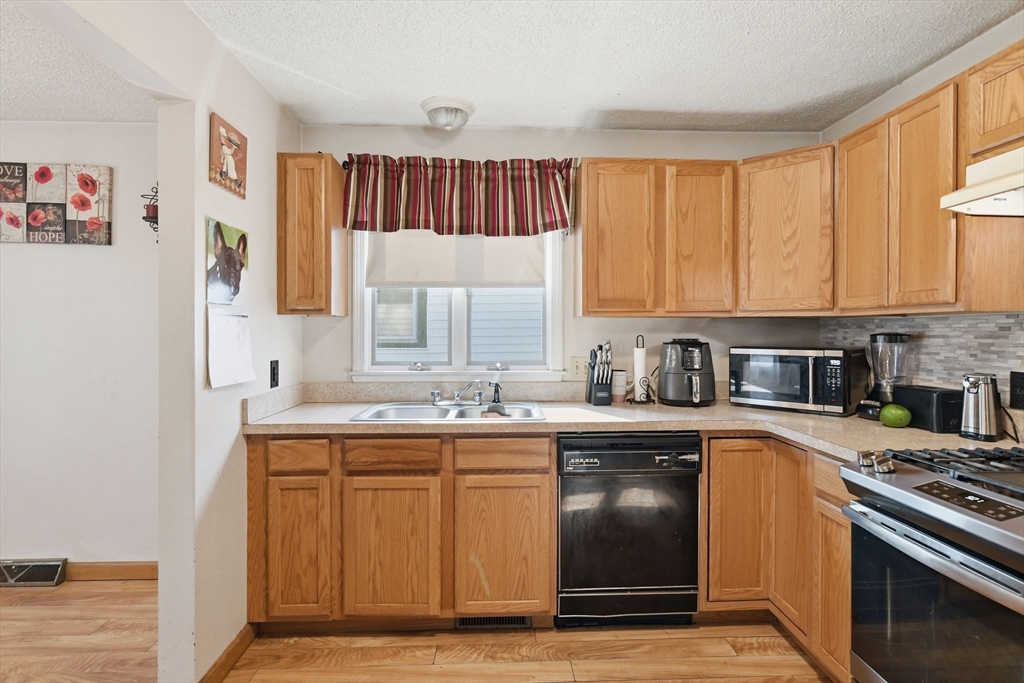 222 Edendale Street Springfield, MA 01104 - Photo 14 of 36 a kitchen with stainless steel appliances granite countertop a sink stove and refrigerator