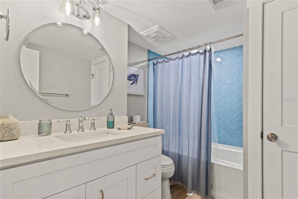 6035 Sea Ranch Drive, Unit 203 Hudson, FL 34667 - Photo 17 of 55 a bathroom with a sink a mirror a vanity and a shower