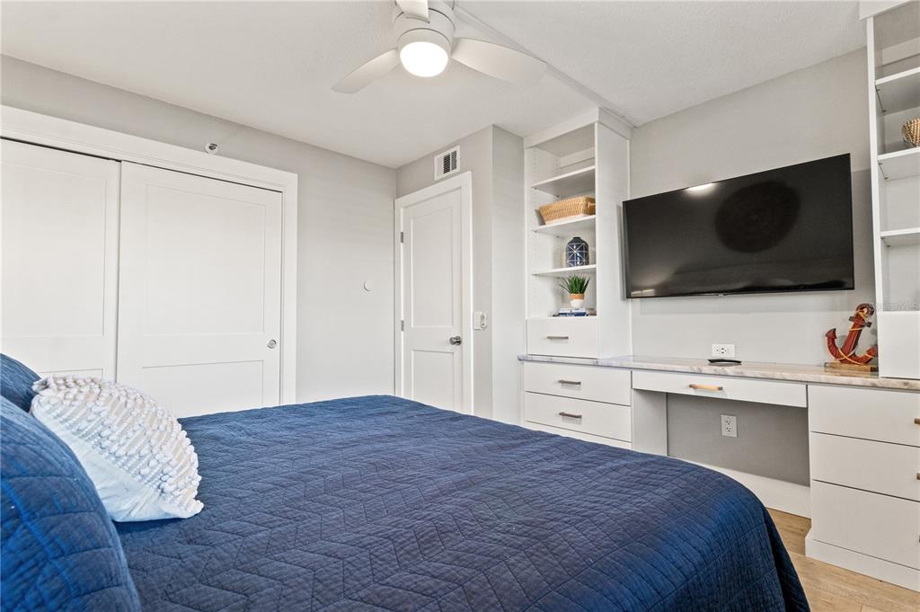 6035 Sea Ranch Drive, Unit 203 Hudson, FL 34667 - Photo 19 of 55 a spacious bedroom with a bed and a flat screen tv