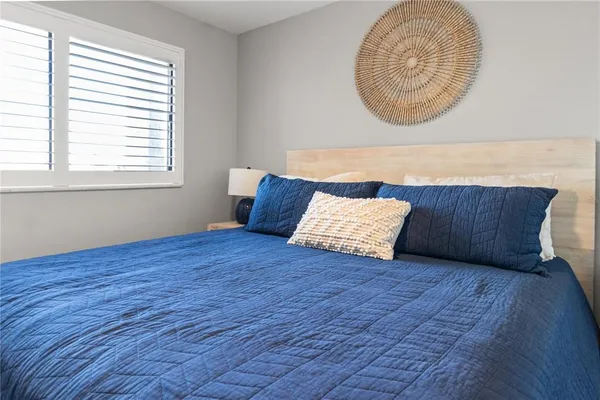 a vase of flowers sitting next to a table and a potted plant
