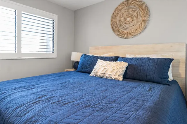 a vase of flowers sitting next to a table and a potted plant
