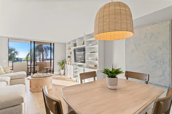 a dining room with table chairs and a potted plant