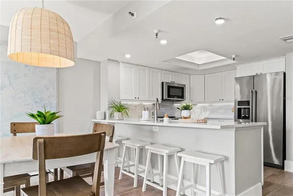 a kitchen with a table chairs refrigerator and microwave
